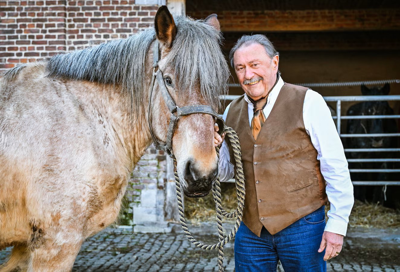 Marijn Devalck bij een Belgisch trekpaard op het erf van de stoeterij